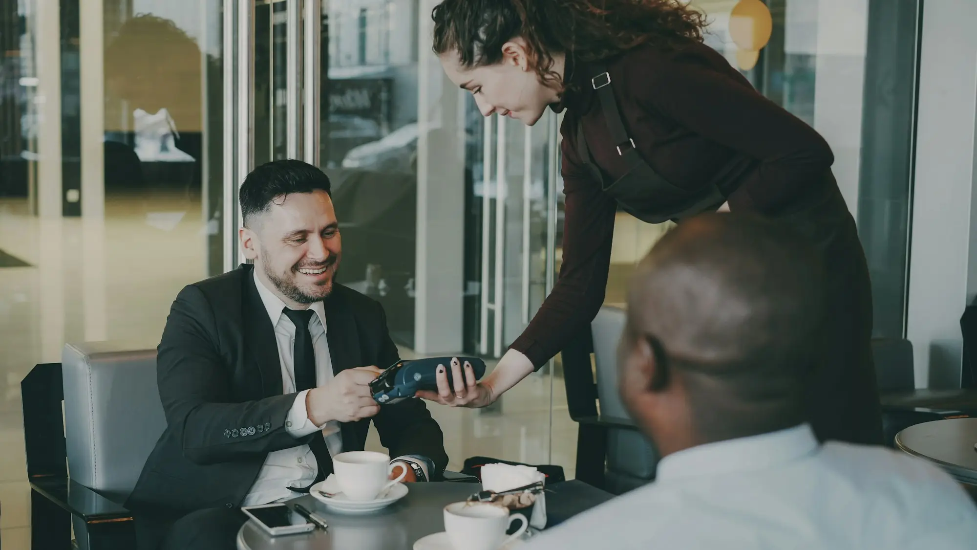 Two men talking at a café table
